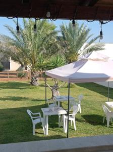a table and chairs under a white umbrella at Villa Alfea CAMERE in Porto Cesareo