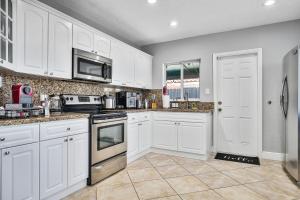 a kitchen with white cabinets and stainless steel appliances at Vacay Spot Happy Escape 15 Min Beach Massage Shower Prime LOC! 6 blocks away from Bars, Nite Clubs, Res, Shops in Miami