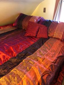 a bed with a colorful comforter and pillows on it at chezbevet in Woodstock