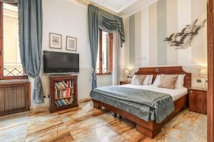 a bedroom with a bed and a flat screen tv at Spagna Dream Suites in Rome