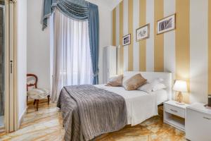 a bedroom with a bed and a striped wall at Spagna Dream Suites in Rome