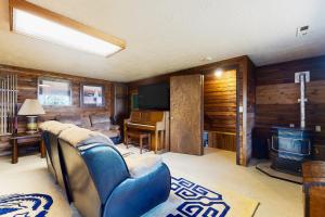 uma sala de estar com um sofá azul e uma televisão em The Coffee Grounds em Johnson Landing