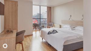 a bedroom with a bed and a desk and a window at Center Hotels Plaza in Reykjavík