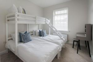 - une chambre avec 2 lits superposés et un bureau dans l'établissement The Views Cottage, à Newcastle