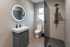 ein Badezimmer mit einem WC, einem Waschbecken und einem Spiegel in der Unterkunft The Views Cottage in Newcastle