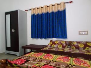 um quarto com uma cama e uma cortina azul em Nithin homestay, private 3bedrooms house,madikeri em Madikeri