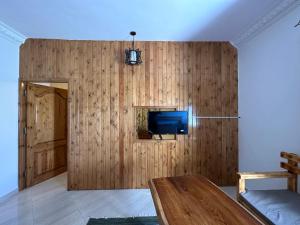 a living room with a wooden wall with a tv at Beit Tolba in Dahab