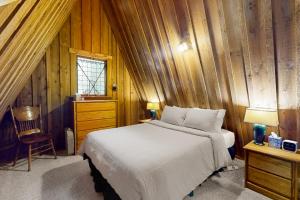 a bedroom with a bed and a wooden wall at Hildas Briarwood Escape in Rhododendron