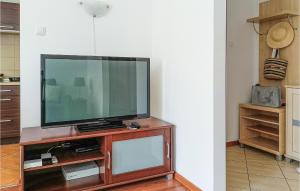 a flat screen tv sitting on top of a wooden entertainment center at Nice Apartment In Kolobrzeg With 1 Bedrooms And Wifi in Kołobrzeg