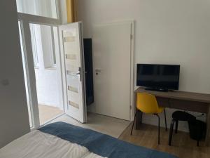 1 dormitorio con escritorio, ordenador y silla amarilla en RES City Residence Hotel Budapest en Budapest