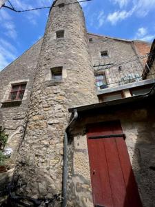 a brick building with a tower with a red door at Studio Bardin in La Charité-sur-Loire