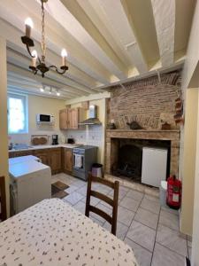 a kitchen with a fireplace and a table and a dining room at Studio Bardin in La Charité-sur-Loire