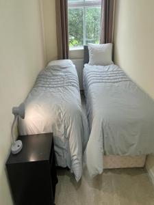 two beds in a room with a window at Bethel Apartments in Leeds