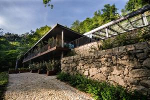 ein Haus mit einer Steinmauer in der Unterkunft Quinta dos Carqueijais Gerês in Geres