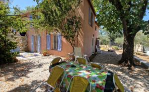 een tafel en stoelen voor een gebouw bij Les Amandiers in Grasse