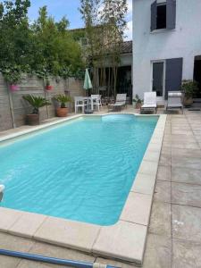 uma grande piscina azul em frente a um edifício em Très belle villa , calme et cosy ,6 personnes 10 mns des plages em Martigues