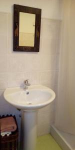 een badkamer met een witte wastafel en een spiegel bij Apartamento Valdesquí in Valdelinares