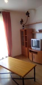 a living room with a table and a tv at Apartamento Valdesquí in Valdelinares