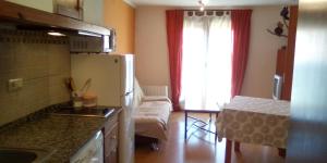 cocina con nevera y sofá en una habitación en Apartamento Valdesquí, en Valdelinares
