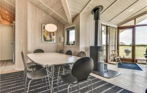 jadalnia ze stołem, krzesłami i kominkiem w obiekcie 4 Bedroom Amazing Home In Rudkbing w mieście Spodsbjerg
