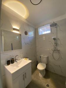 a white bathroom with a toilet and a sink at דירת אירוח ימית in Bet Sheʼan