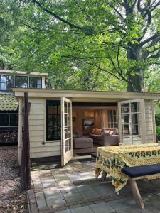 ein kleiner Schuppen mit einem Tisch und einer Couch in der Unterkunft Cottage Het Beukenootje in Aerdenhout