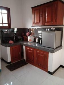 a kitchen with wooden cabinets and a counter top at Sathis villa in Ambalangoda