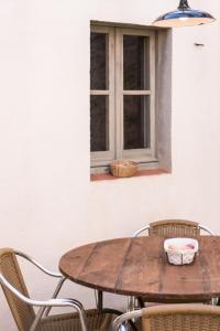 een houten tafel en stoelen voor een raam bij Ca la Merce Batista in Palau-Saverdera