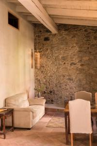 a living room with a couch and a stone wall at Ca la Merce Batista in Palau-Saverdera