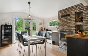 a kitchen with a dining table and a brick wall at Cozy Home In Jgerspris With Jacuzzi in Jægerspris