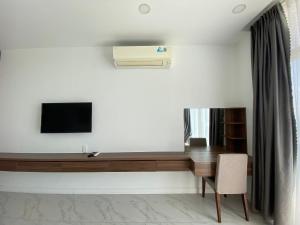 Cette chambre comprend un bureau avec une télévision et une chaise. dans l'établissement Căn hộ view biển Sea Links MŨI NÉ, à Phan Thiết