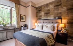 a bedroom with a large bed and a wooden wall at Eton House - Self Check-In, Ensuite Rooms & Self-Catering Studios in Yeovil