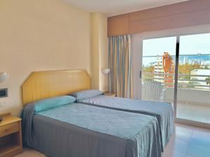 1 dormitorio con 1 cama y balcón con vistas. en AR Roca Esmeralda & SPA Hotel en Calpe