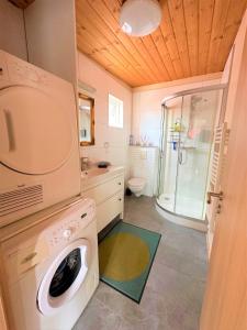y baño con ducha y lavadora. en Beautiful lakehouse by the golden circle - fishing, en Selfoss