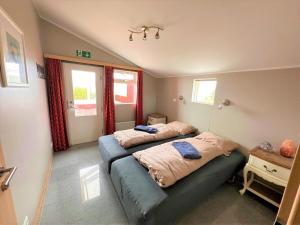 a bedroom with two beds and a window at Beautiful lakehouse by the golden circle - fishing in Selfoss