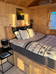1 dormitorio con 1 cama en una cabaña de madera en Roulotte „douceur“ en Condom