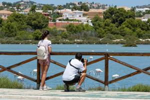 a man taking a picture of a woman looking at birds at AR Roca Esmeralda & SPA Hotel in Calpe