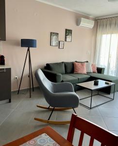 een woonkamer met een groene bank en een tafel bij SnappyB - Colours in Alexandroupoli