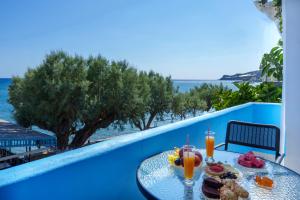 a table with food and drinks on a balcony at Star Beach apartment in Kastrí
