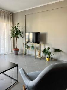 een woonkamer met een bank en een tv bij SnappyB - Colours in Alexandroupoli