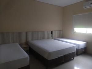 Hotel Nova Geração tesisinde bir odada yatak veya yataklar