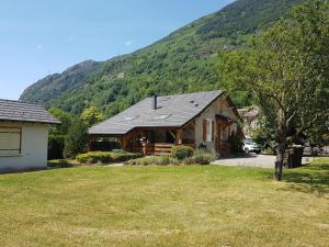 a log cabin with a mountain in the background at Ouxis in Orlu