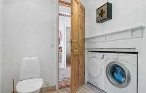 uma lavandaria com uma máquina de lavar roupa e um WC em Trojlhyttan em Bedegård
