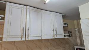a kitchen with white cabinets on the wall at Springfield in Nairobi