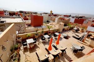 a patio with tables and chairs on top of a building at Riad Dar Haven in Tamraght Ou Fella