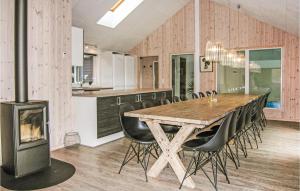 uma cozinha e sala de jantar com uma mesa de madeira e uma lareira em Stunning Home In Tranekr With 7 Bedrooms, Wifi And Outdoor Swimming Pool em Hou