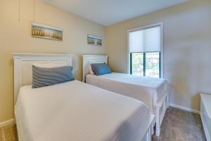 two beds in a room with a window at Lakefront Michigan Rental with Kayak and Fire Pit 