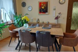 uma sala de jantar com uma mesa de madeira e cadeiras em Ferienwohnung am Gipsberg em Merzig