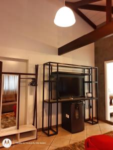 a living room with a flat screen tv on a shelf at Hotel Vila Germânica in Blumenau