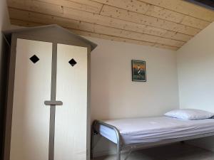 Bett in einem Zimmer mit Holzdecke in der Unterkunft Maison bois neuve tout confort, au calme in Messanges